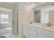 Bright bathroom features double vanity sinks with white cabinets and a view of the shower at 221 Ruthe Cv, Locust Grove, GA 30248