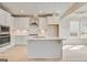 Modern kitchen with stainless steel appliances, sleek white cabinetry, and an eat-in island at 221 Ruthe Cv, Locust Grove, GA 30248