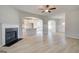 Spacious living room boasts a fireplace, ceiling fan, neutral walls, wood-look flooring, and open access to the kitchen at 221 Ruthe Cv, Locust Grove, GA 30248