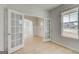 Bright living room featuring French doors, hardwood floors and large windows at 221 Ruthe Cv, Locust Grove, GA 30248