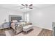 Well-lit main bedroom features a large upholstered headboard, ceiling fan and plush decor at 2694 Greentree Se Dr, Marietta, GA 30067