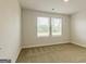 Bright, carpeted bedroom with two large windows offers a welcoming space, showcasing natural light and a neutral palette at 506 Alford Cv # 89, Fairburn, GA 30213