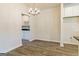 Open dining area with sleek chandelier and wood-look flooring, adjacent to built-in wine rack and cabinets, blending style and functionality at 506 Alford Cv # 89, Fairburn, GA 30213
