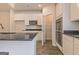 Bright kitchen boasts white cabinets, stainless steel appliances, dark countertops, and an adjacent pantry for ample storage at 506 Alford Cv # 89, Fairburn, GA 30213