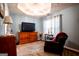 Cozy bedroom featuring a TV, hardwood floors, a chair, and a ceiling fan at 1612 Cagle Ct, Lawrenceville, GA 30045