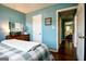Bedroom featuring blue walls, hardwood floors, a dresser, and a door that leads to another room at 1612 Cagle Ct, Lawrenceville, GA 30045
