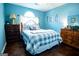 Bedroom featuring blue walls, hardwood floors, two wooden dressers, and a ceiling fan at 1612 Cagle Ct, Lawrenceville, GA 30045