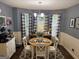 Cozy dining area with a round table, white chairs, a bay window, and decorative curtains at 1612 Cagle Ct, Lawrenceville, GA 30045