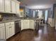 Elegant kitchen features white cabinetry, granite countertops, mosaic backsplash, stainless steel appliances, and hardwood floors at 1612 Cagle Ct, Lawrenceville, GA 30045