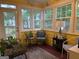 Bright sunroom with yellow walls, large windows, and comfortable seating area filled with natural light at 1612 Cagle Ct, Lawrenceville, GA 30045