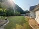 Backyard showcasing a spacious lawn, privacy fence, bordered by decorative rock and a swing set at 240 Turnbridge Cir, Peachtree City, GA 30269