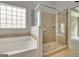 Bathroom showcasing a tiled shower, separate bathtub, and modern fixtures at 240 Turnbridge Cir, Peachtree City, GA 30269