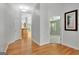Hardwood hallway with bright walls, open doorway, and view of kitchen and bedroom areas at 240 Turnbridge Cir, Peachtree City, GA 30269