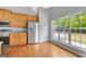 Eat-in kitchen features hardwood floors, stainless steel appliances, and a large window to the outdoor scenery at 240 Turnbridge Cir, Peachtree City, GA 30269