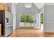 Modern eat-in kitchen with stainless steel appliances, hardwood floors, and a view into the backyard at 240 Turnbridge Cir, Peachtree City, GA 30269