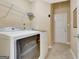 Well-lit laundry room featuring tile floors and storage space, equipped with a modern washing machine at 240 Turnbridge Cir, Peachtree City, GA 30269