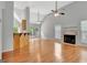 Open-concept living room features high ceilings, hardwood floors, fireplace, and access to the kitchen at 240 Turnbridge Cir, Peachtree City, GA 30269