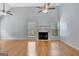 Bright living room featuring high ceilings, hardwood floors, a fireplace, and two ceiling fans at 240 Turnbridge Cir, Peachtree City, GA 30269