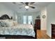 Bright bedroom featuring a wooden bed frame, a floral pattern bedspread, and a ceiling fan at 100 Willow Wood Road, Social Circle, GA 30025