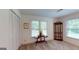 Carpeted bedroom with paneled walls, and a unique display cabinet, flooded with natural light at 100 Willow Wood Road, Social Circle, GA 30025