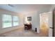 Bedroom with paneled walls, neutral carpet, large window, and a vintage writing desk at 100 Willow Wood Road, Social Circle, GA 30025