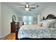 Bright bedroom featuring a wooden bed frame, a floral pattern bedspread, and a ceiling fan at 100 Willow Wood Road, Social Circle, GA 30025