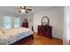 Bright bedroom featuring a wooden bed frame, a floral pattern bedspread, and two dressers at 100 Willow Wood Road, Social Circle, GA 30025
