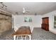 Dining room featuring white chairs, stone flooring, and exposed brick accents at 100 Willow Wood Road, Social Circle, GA 30025