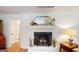 Close up view of a white painted brick fireplace with decorative mantle and hardwood floors at 100 Willow Wood Road, Social Circle, GA 30025