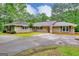 Sprawling single-story home featuring brick exterior, mature trees and long driveway at 100 Willow Wood Road, Social Circle, GA 30025