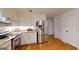 Kitchen with white cabinets, stainless steel refrigerator, and hardwood floors at 100 Willow Wood Road, Social Circle, GA 30025