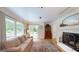 Bright and cozy living room with fireplace, hardwood floors, and sliding glass door access to the backyard at 100 Willow Wood Road, Social Circle, GA 30025