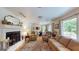 Bright living room with fireplace, hardwood floors, and a dining area near large windows at 100 Willow Wood Road, Social Circle, GA 30025