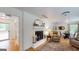 Cozy living room featuring a brick fireplace, hardwood floors, and a comfortable seating area at 100 Willow Wood Road, Social Circle, GA 30025