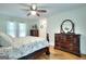 Bright main bedroom with ceiling fan, wood floors, and a large dresser at 100 Willow Wood Road, Social Circle, GA 30025