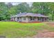 Well-maintained rear view of house, showcasing its large windows and scenic backyard at 100 Willow Wood Road, Social Circle, GA 30025