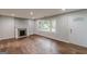 Inviting living room features hardwood floors, fireplace, large window, and painted brick accent wall at 489 Radar Dr, Hapeville, GA 30354