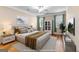 Staged bedroom features a large bed, hardwood floors, a ceiling fan, and two windows at 130 Augusta Dr, Peachtree City, GA 30269