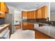Well-lit kitchen features wood cabinets, granite countertops, stainless steel appliances, and tiled floors at 130 Augusta Dr, Peachtree City, GA 30269