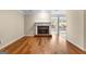Living room featuring hardwood floors, a brick fireplace, and a view into the sunroom at 130 Augusta Dr, Peachtree City, GA 30269