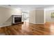 Bright living room featuring hardwood floors, a brick fireplace, and large windows at 130 Augusta Dr, Peachtree City, GA 30269