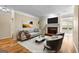 Staged living room with hardwood floors, fireplace, and neutral furniture at 130 Augusta Dr, Peachtree City, GA 30269
