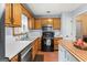 Functional kitchen features wood cabinets, stainless steel dishwasher, gas range, and ample prep space at 200 Pine Tree Ln, Mcdonough, GA 30252