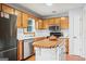 Charming kitchen boasts wood cabinets, stainless steel appliances, island, and bright white countertops at 200 Pine Tree Ln, Mcdonough, GA 30252