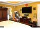 Primary bedroom featuring tray ceilings, hardwood floors, and a large television at 9342 Carillon Ct, Jonesboro, GA 30236