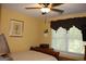 This bedroom has a ceiling fan, yellow walls, and a window letting in natural light at 9342 Carillon Ct, Jonesboro, GA 30236