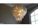 Close up view of a modern chandelier with unique glass fixtures and subtle lighting at 9342 Carillon Ct, Jonesboro, GA 30236