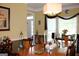 Formal dining room with hardwood table, decorative chandelier, and large window at 9342 Carillon Ct, Jonesboro, GA 30236
