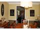 Dining area showcasing a wooden table, decorative light fixture, and view into the kitchen at 9342 Carillon Ct, Jonesboro, GA 30236