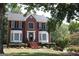 Charming red brick two-story home with a well-manicured lawn and nicely landscaped flower beds at 9342 Carillon Ct, Jonesboro, GA 30236